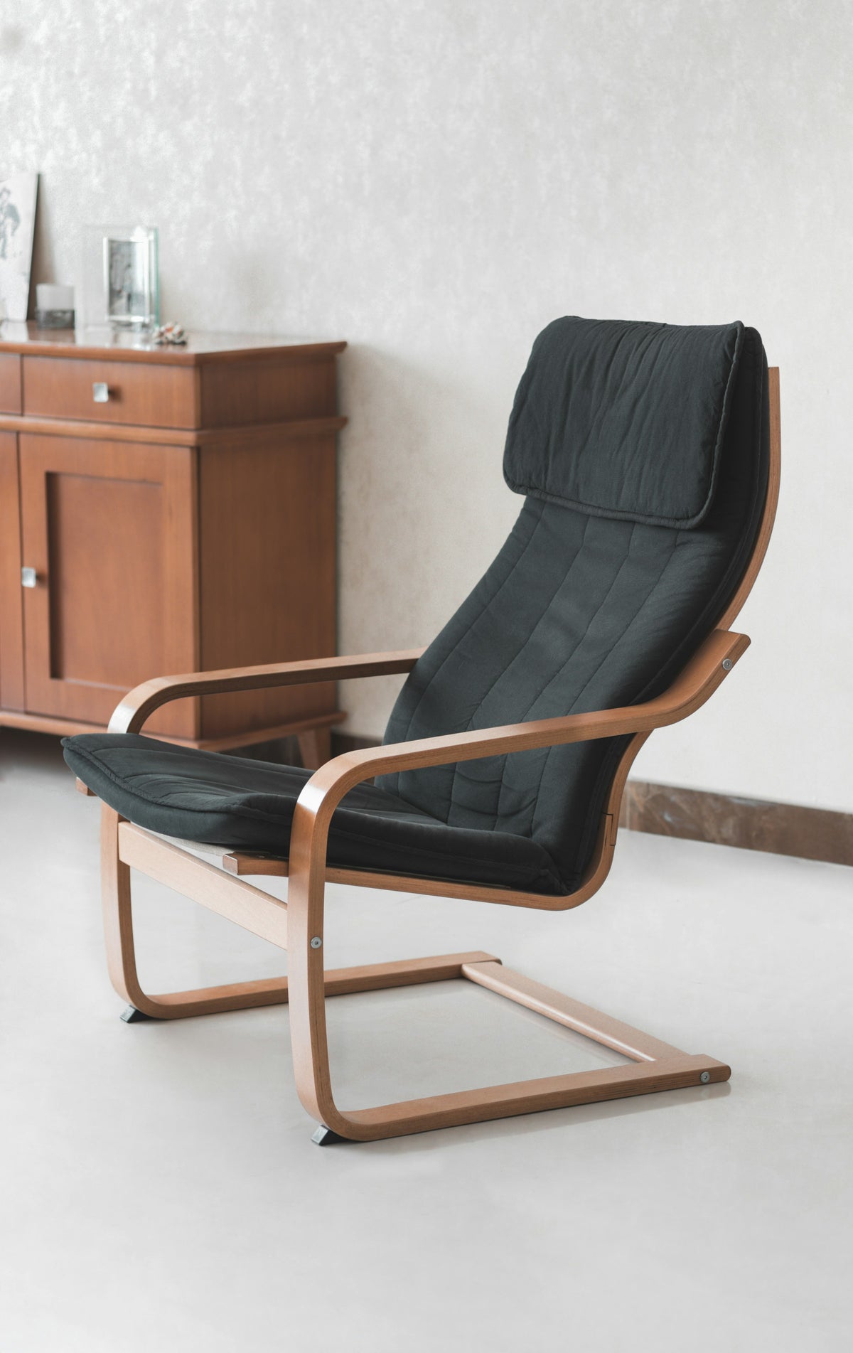 Wooden lounge chair with dark cushions