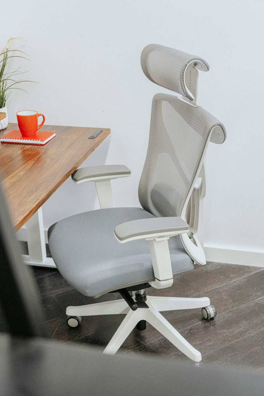 Grey office chair beside a wooden desk